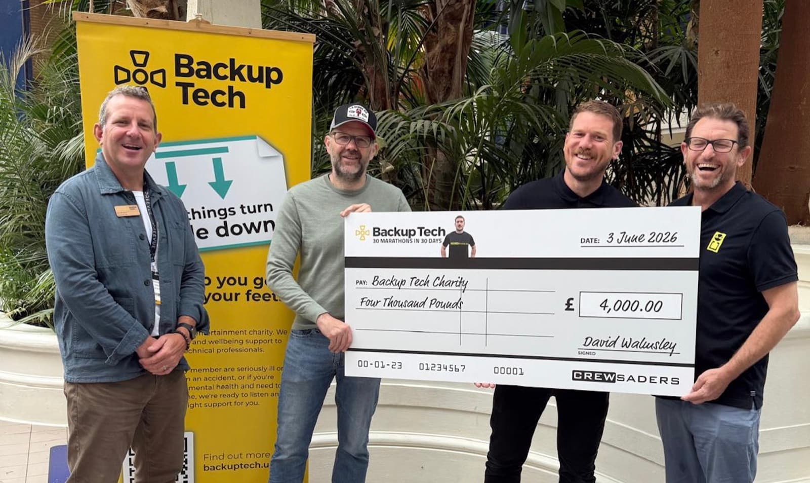 David Walmsley presents a £4,000 cheque to Lee Dennison of Backup Tech alongside Crewsaders Managing Director Jez Berryman at the ABTT Theatre Show, Alexandra Palace