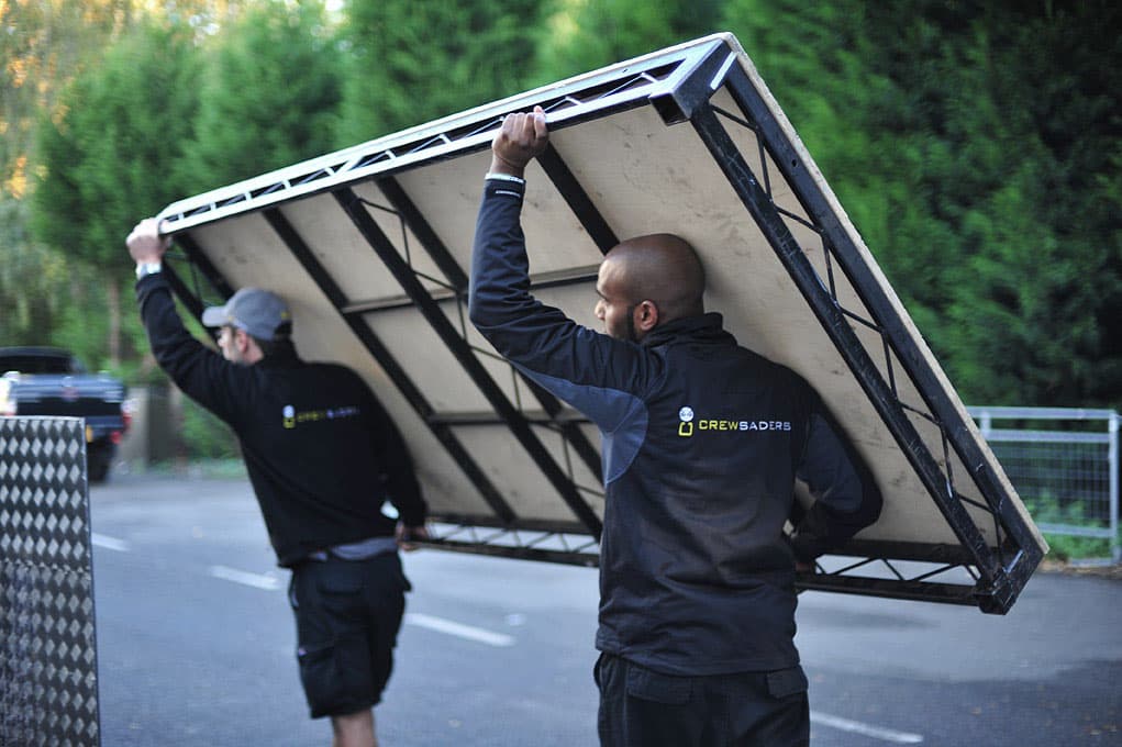 Crew members lifting stage equipment safely