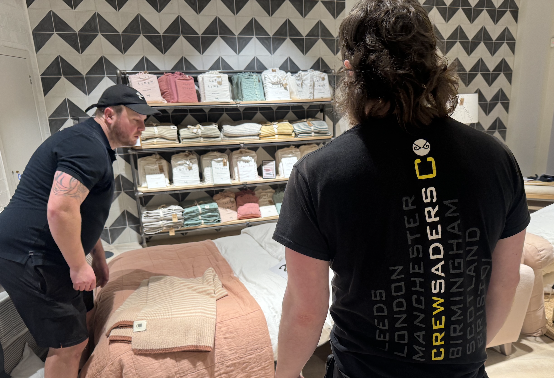 Crewsaders crew helping an exhibitor arrange retail stock and display shelving on stand